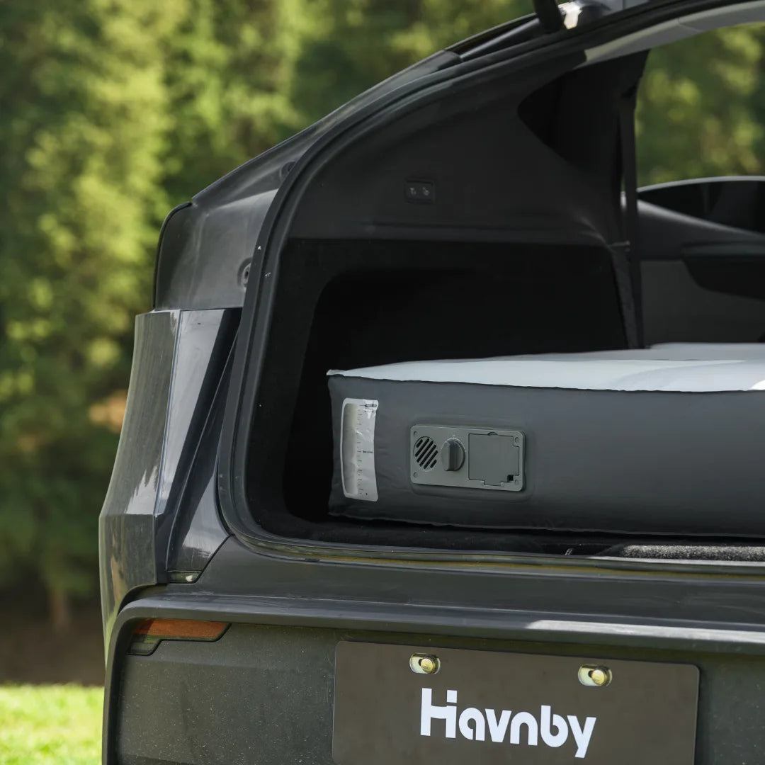 HAVNBY car-camping mattress set up in the open trunk of a vehicle parked outdoors