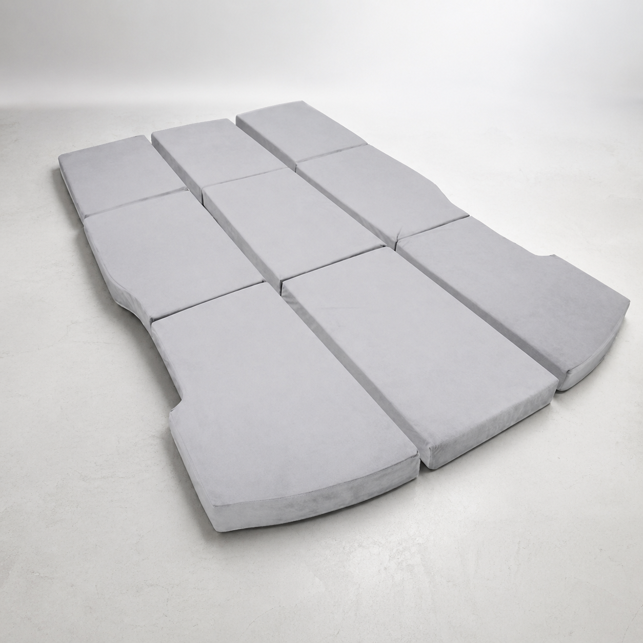 Gray foam cushions arranged in a curved pattern on a white background
