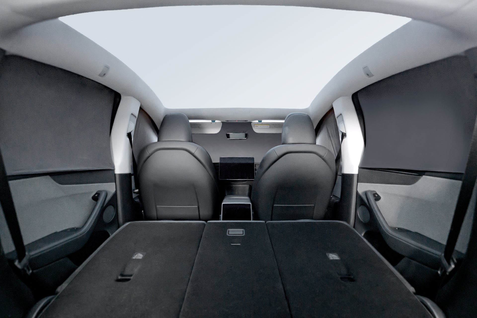 All windows of Tesla Model Y fully covered by privacy shades – night view inside car