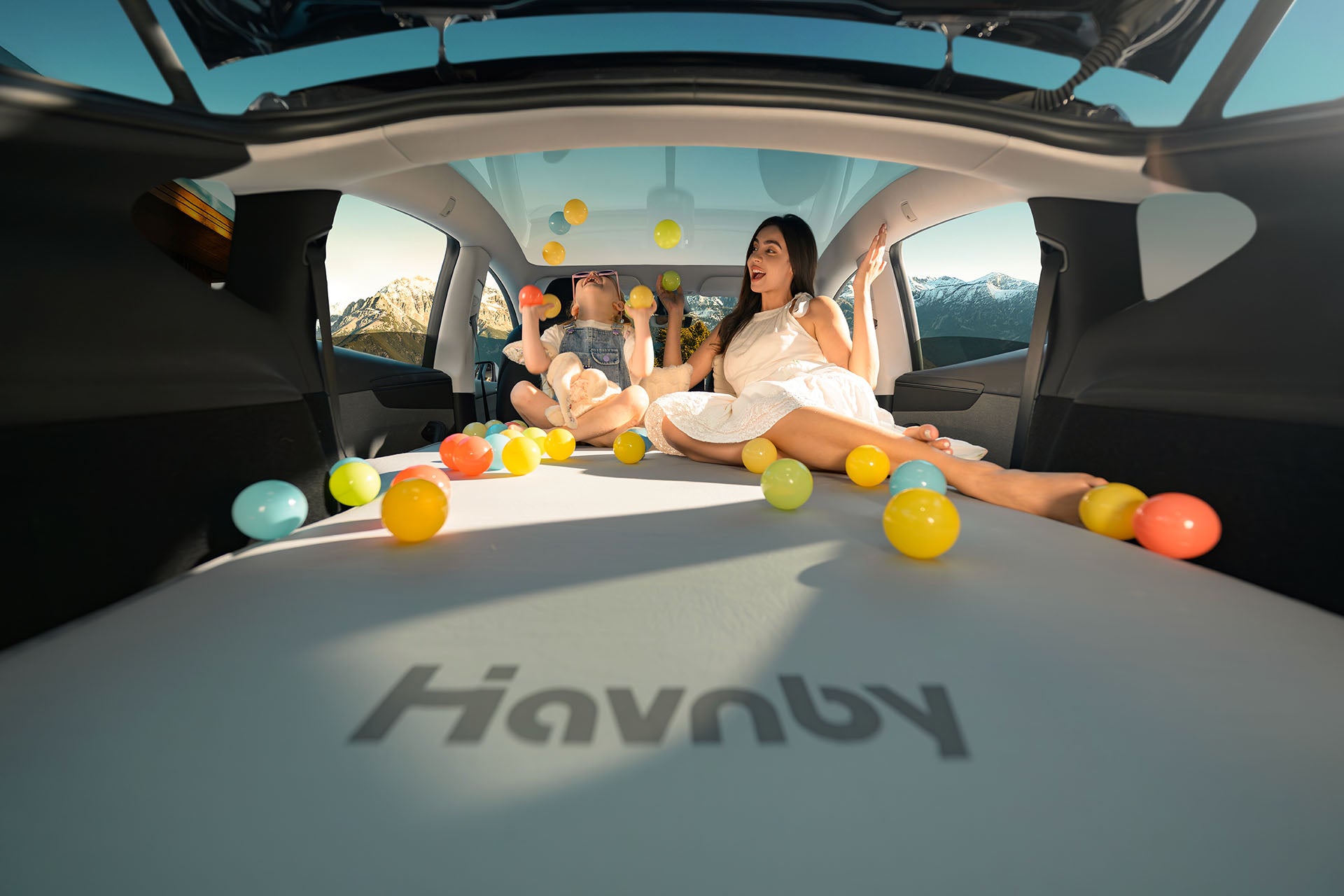 Family and pet relaxing on Havnby 7.5 inch auto-leveling foam mattress inside Tesla Model Y